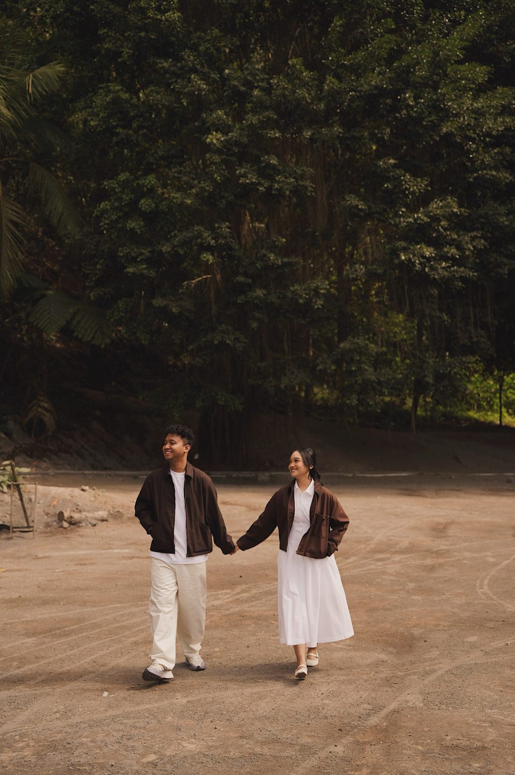 Brian dan Sasa berjalan bergandengan tangan sambil saling tersenyum
